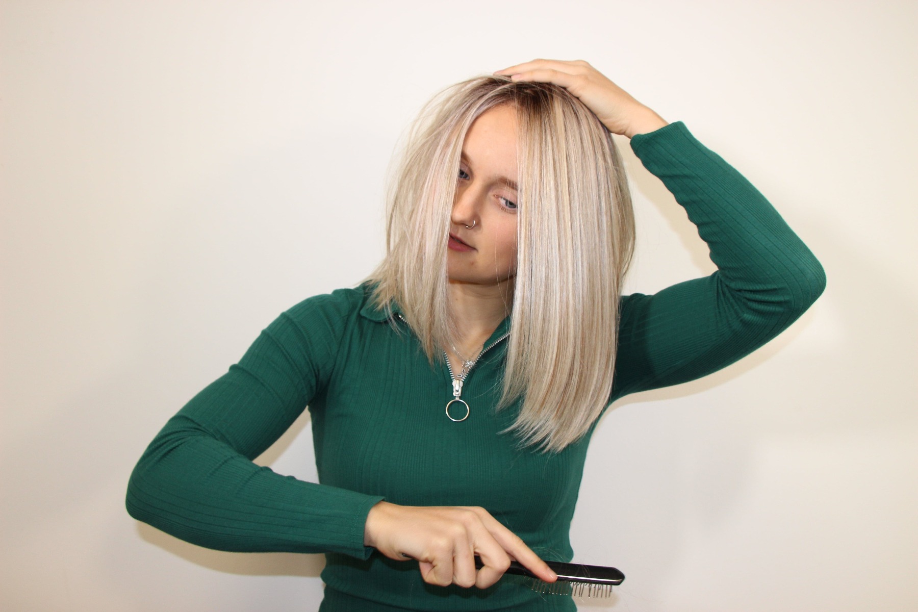 Lady gently brushing her wig with a synthetic fibre wig metal brush